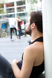 Portrait of a young man with beard sitting outdoors