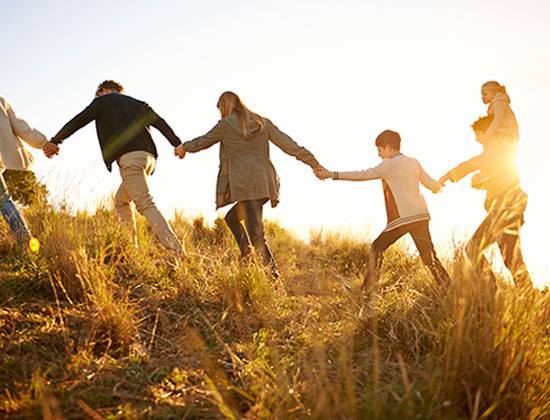 family walking together sun grass travel bonding