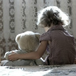 child sitting with teddy bear light